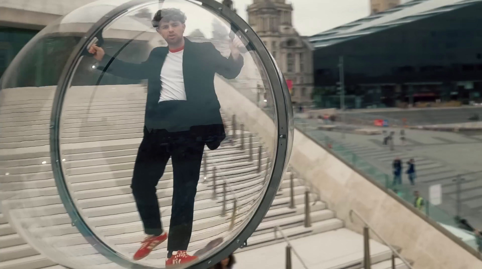 a man in a suit standing inside of a glass ball