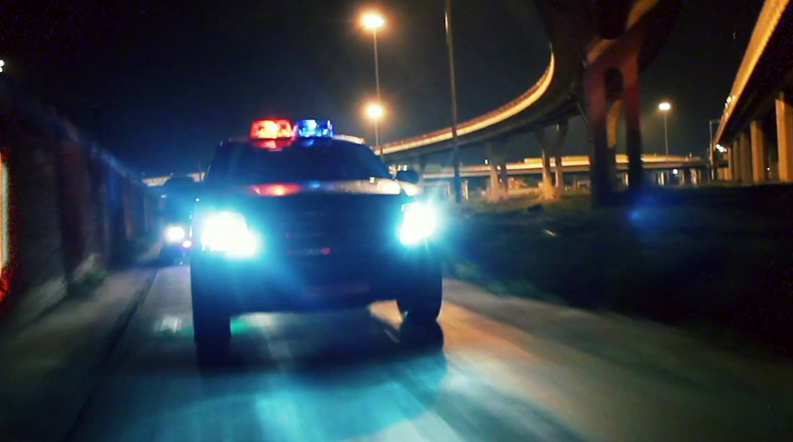 a police car driving down a street at night