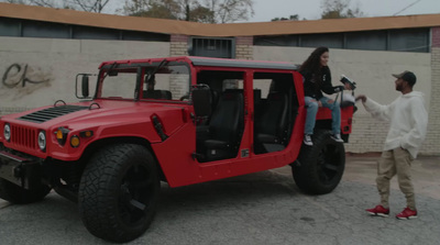 a man and a woman standing next to a red jeep