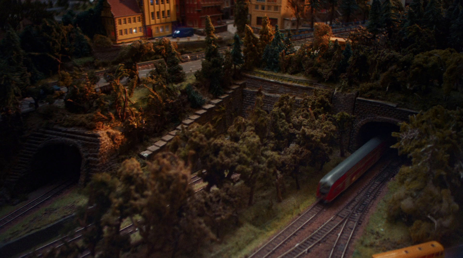 a train traveling through a tunnel next to a lush green forest