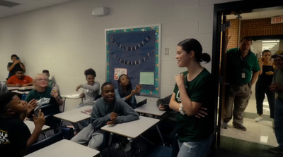 a group of people sitting at desks in a classroom