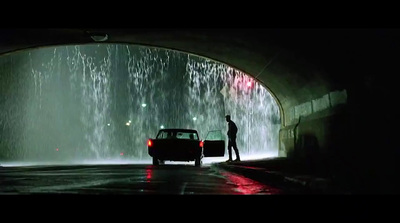 a man standing next to a car in a tunnel