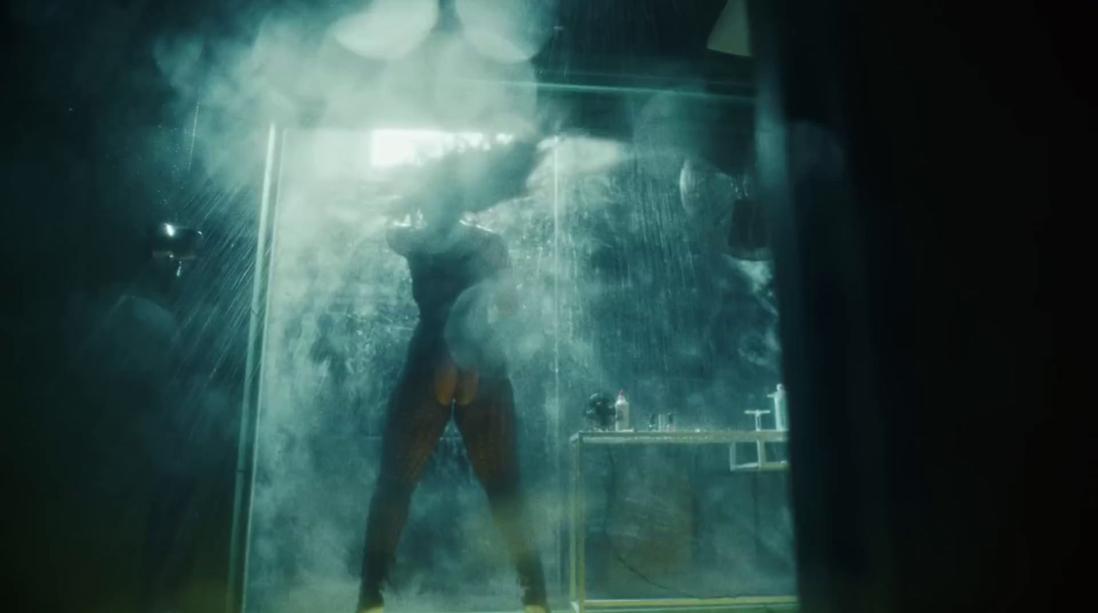 a man standing in a shower in a dark room