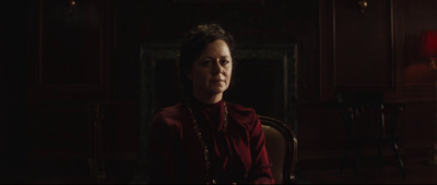 a woman sitting in a chair in a dark room