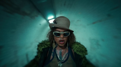 a woman wearing sunglasses and a hat in a tunnel