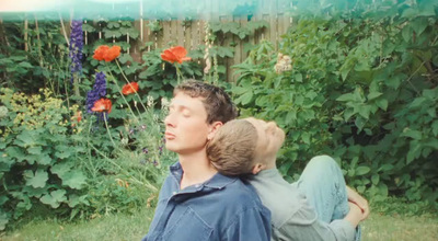 a boy and a girl are sitting in the grass