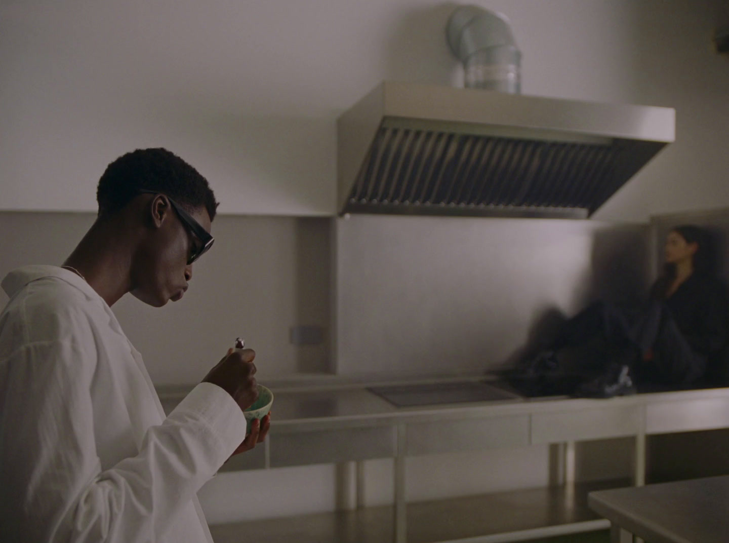 a man standing in a kitchen looking at his cell phone