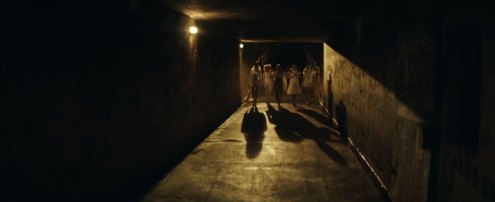 a group of people walking down a dark hallway