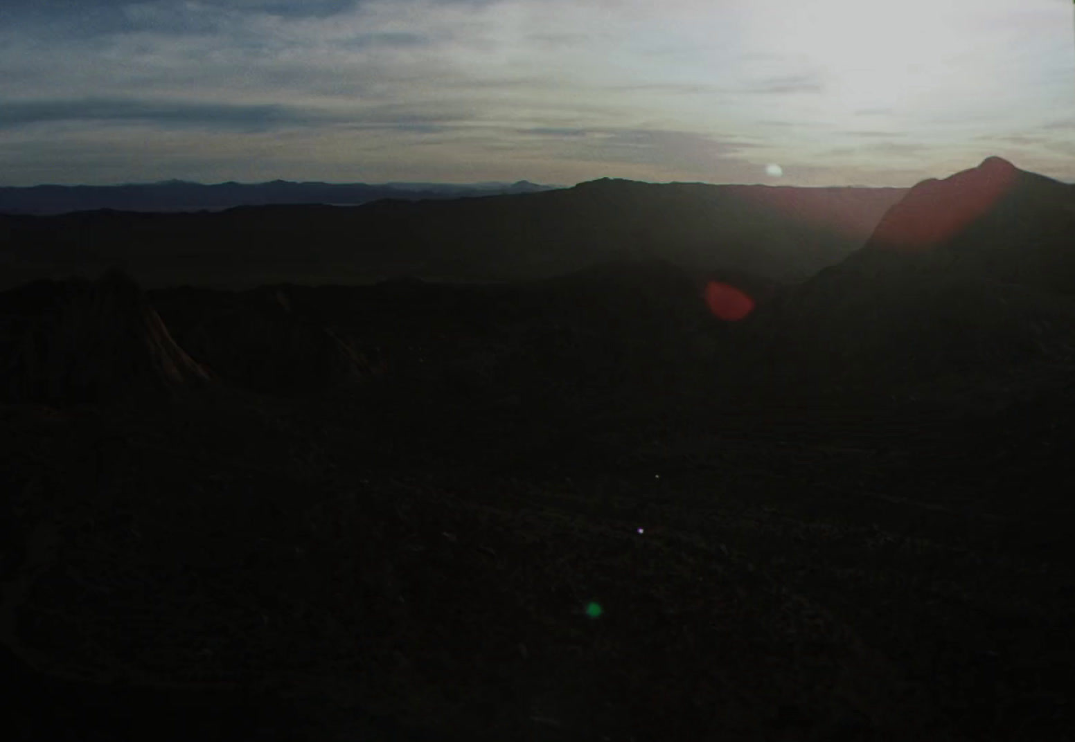 the sun is setting over a mountain range