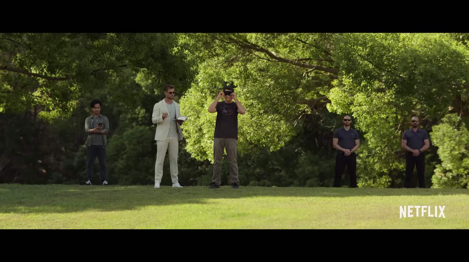 a group of men standing on top of a lush green field