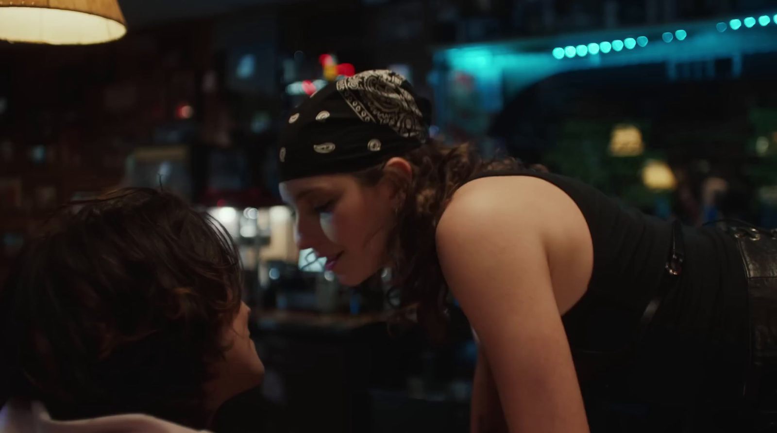 a woman with a bandana on her head looking at another woman