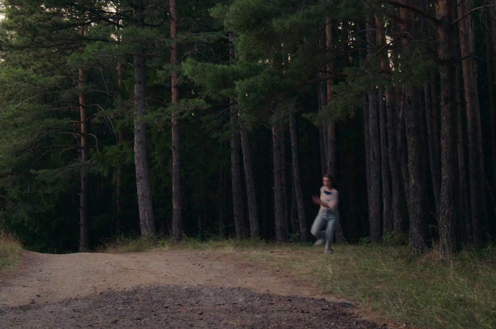 a man running in the woods with a frisbee