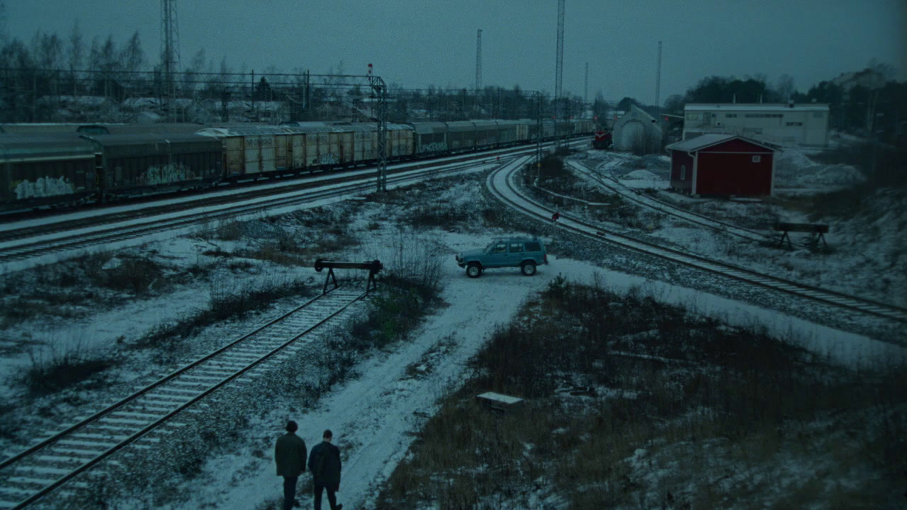 a couple of people walking down a snow covered train track