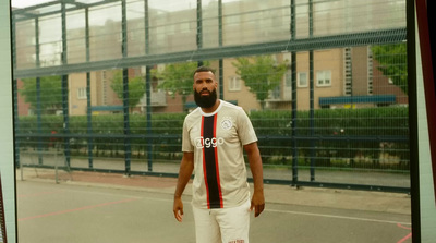 a man with a beard standing on a basketball court