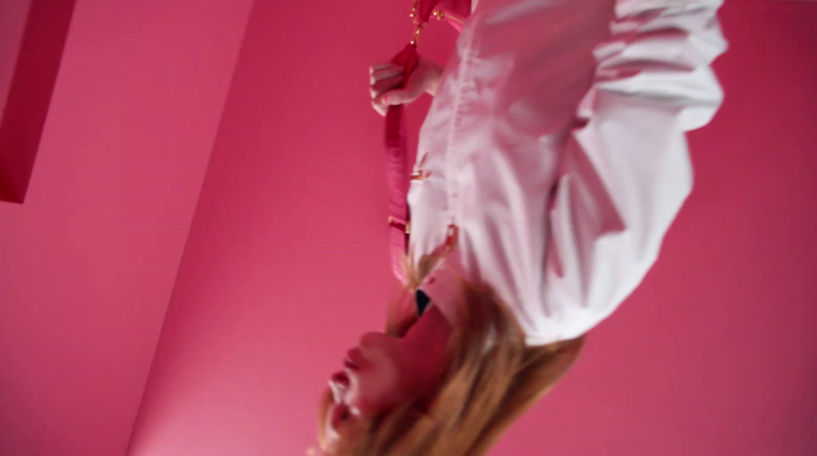 a woman in a white shirt and a pink background