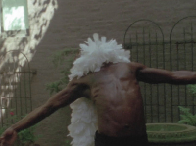 a man with a feathered headdress is walking down the street