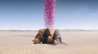 a group of people sitting on top of a sandy field