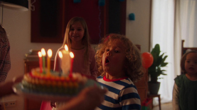 a little girl blowing out candles on a birthday cake