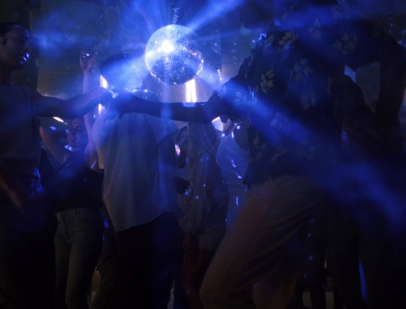 a group of people standing around a disco ball