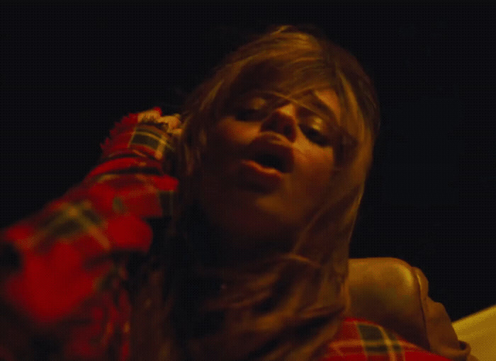 a woman with her eyes closed wearing a plaid shirt