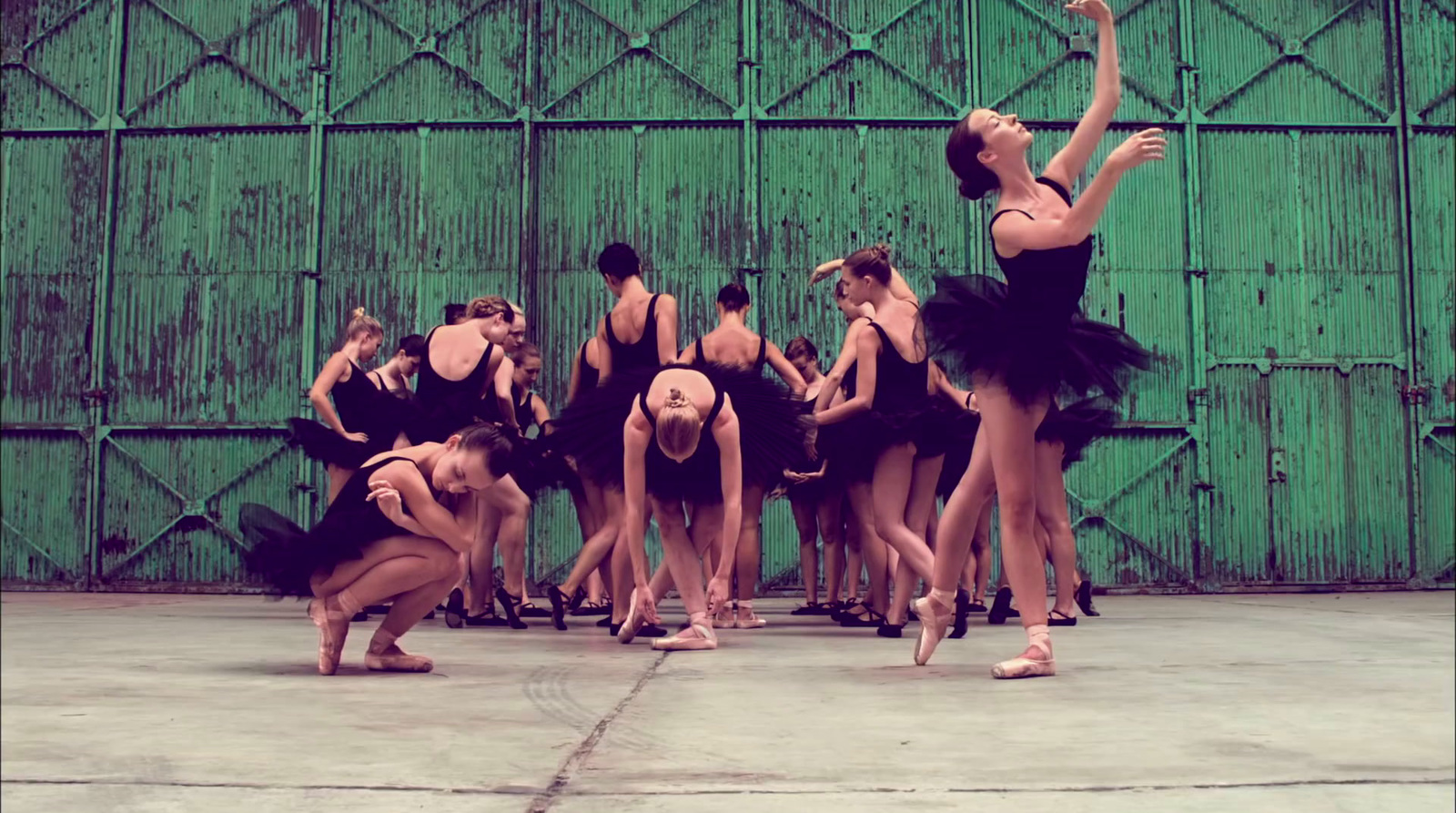 a group of ballerinas in front of a green wall