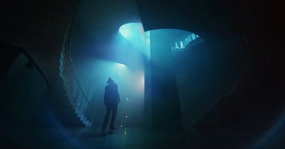 a person standing in a dark room with stairs