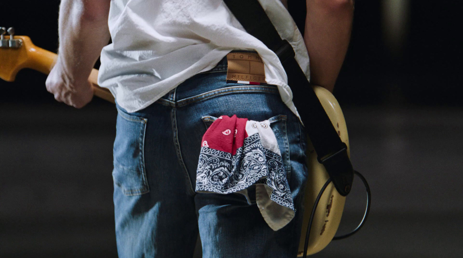 a person with a guitar case in their back pocket