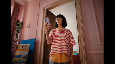 a woman standing in front of a mirror holding a cell phone