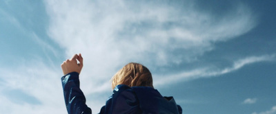 a woman is flying a kite in the sky