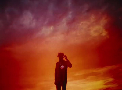 a man standing on top of a hill under a cloudy sky