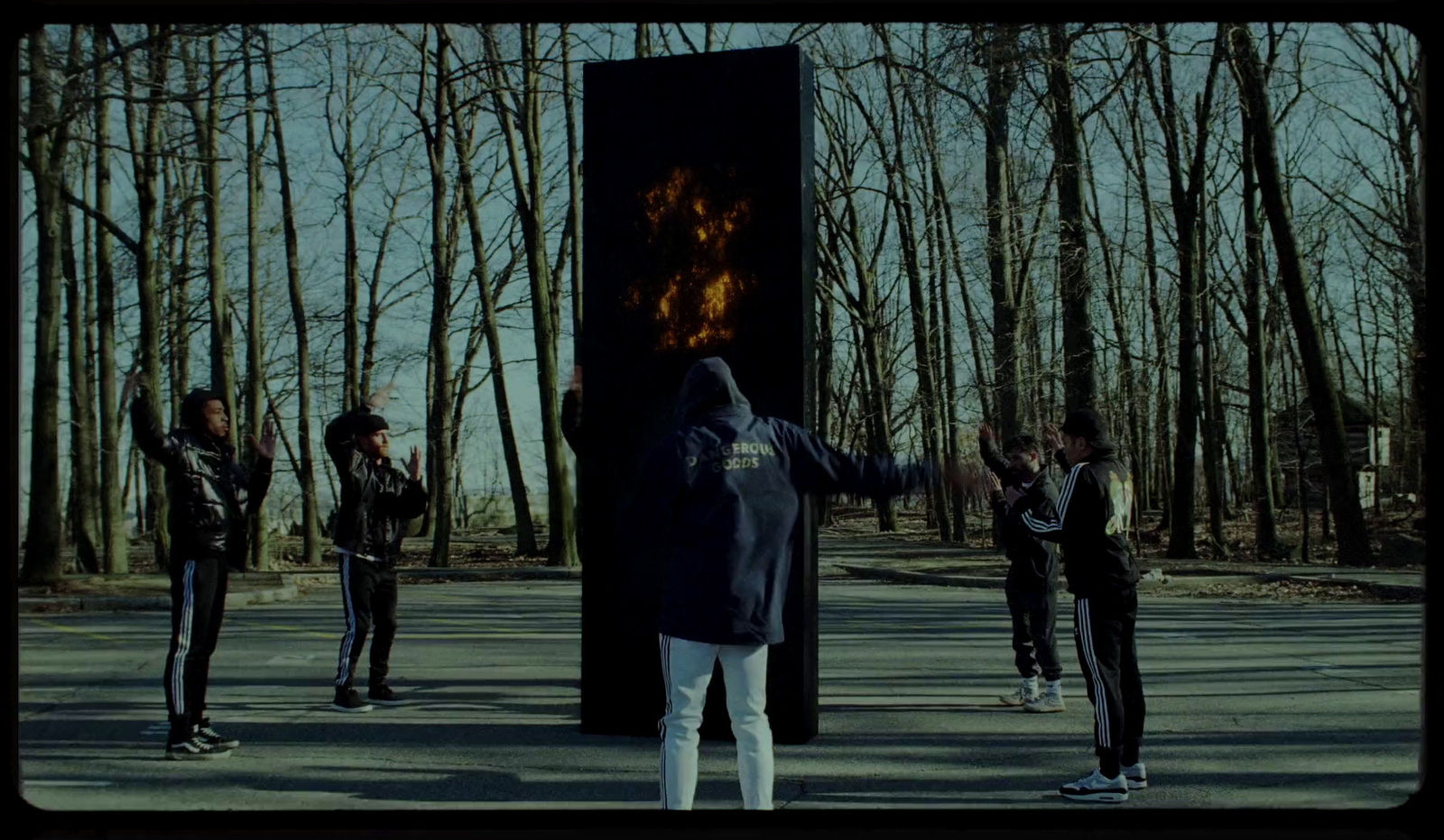 a group of people standing in front of a fire