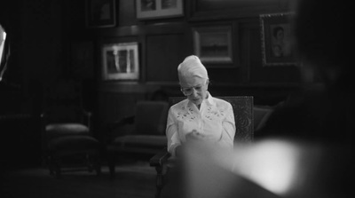 a woman sitting in a chair looking at her cell phone