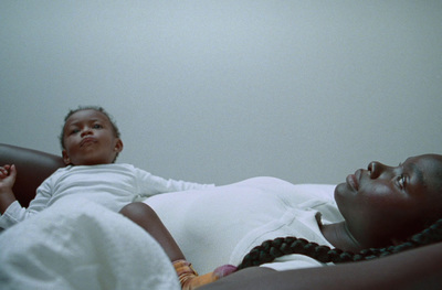 a woman laying in bed next to a child