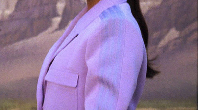 a woman in a purple suit is smiling at the camera