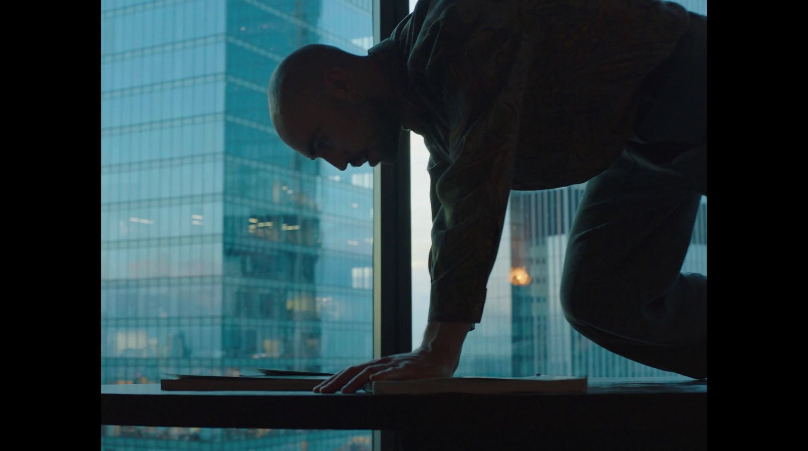 a man leaning over a table in front of a window