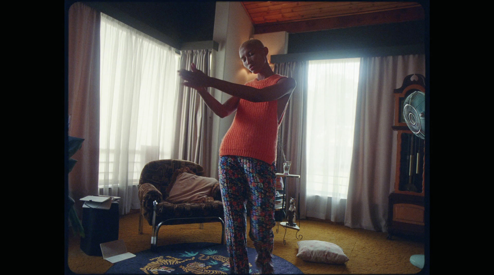 a woman standing in a living room holding a wii mote