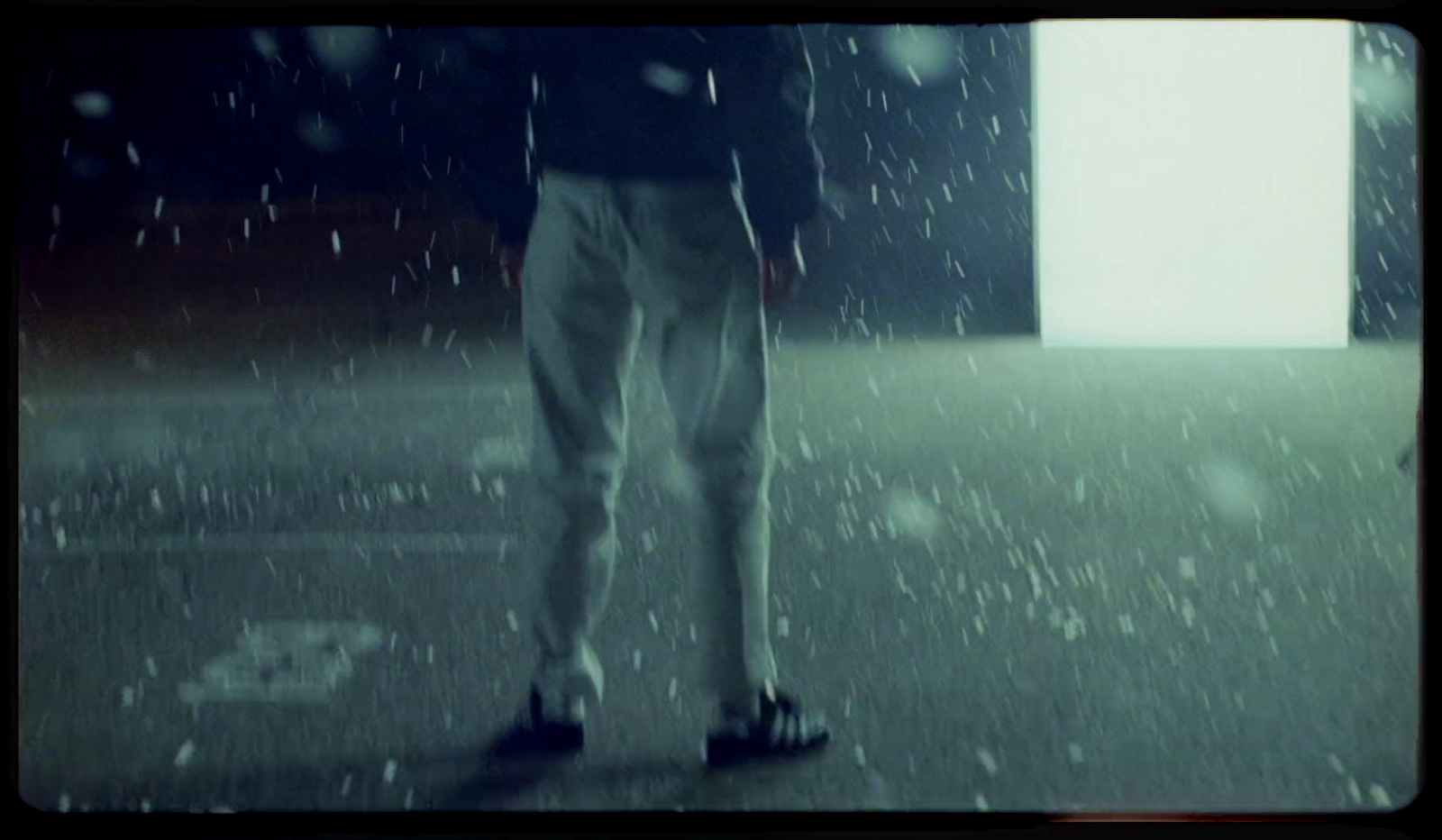 a man standing in the rain with his foot on the ground