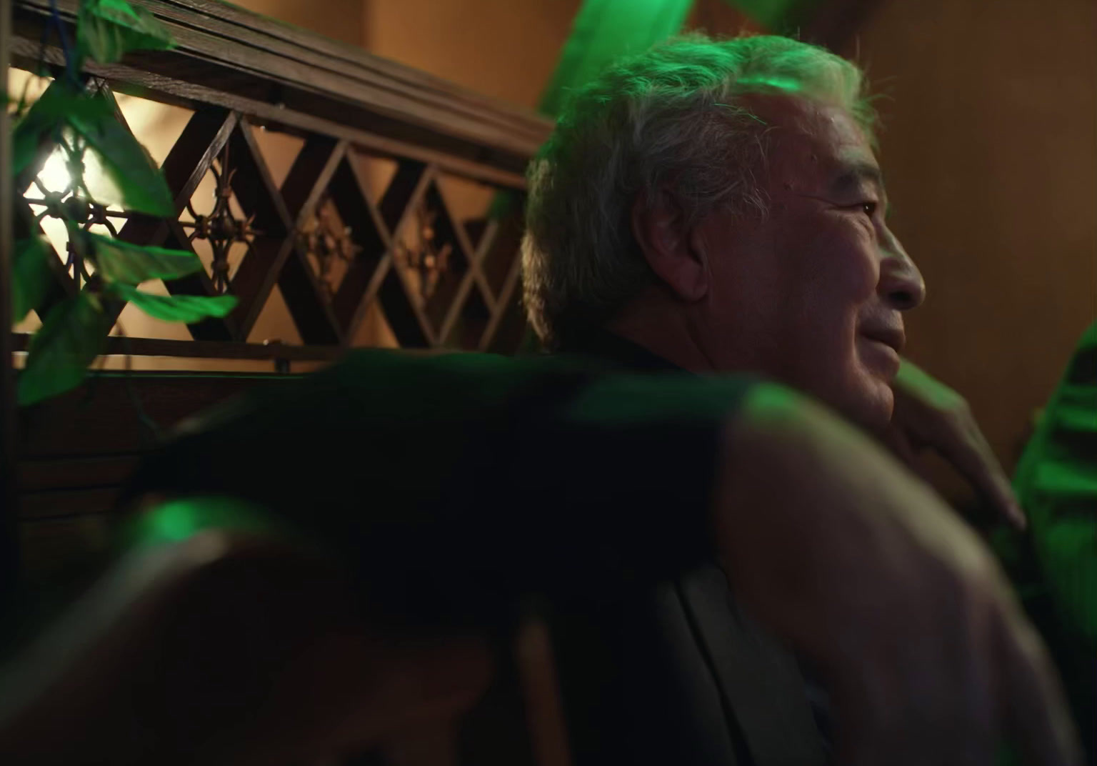 a man sitting in a chair with a green light on his face