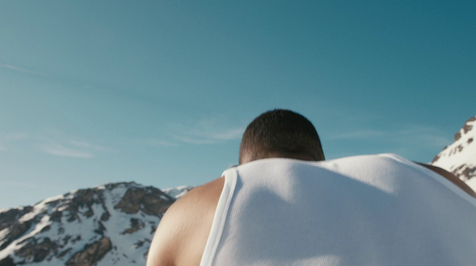 a man with a towel on his back in front of a mountain