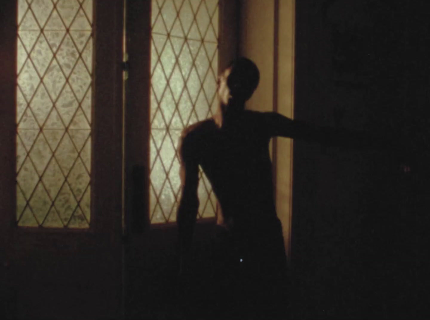 a man standing in front of a door in a dark room