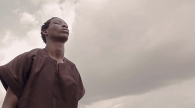 a person standing in front of a cloudy sky