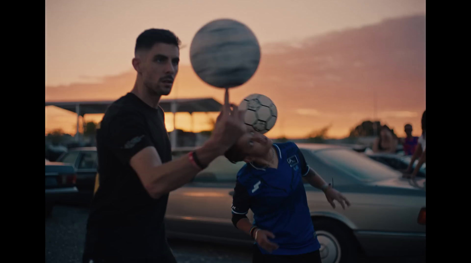 a man holding a soccer ball over another man's head