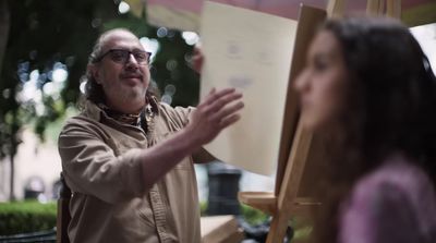 a man standing next to a woman holding a piece of paper