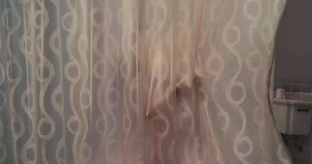 a person's reflection is seen through a shower curtain