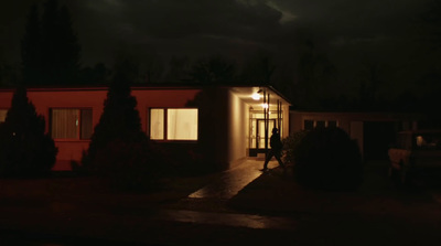 a house lit up at night with a cloudy sky