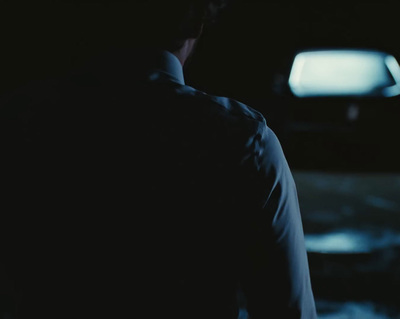 a man standing in a dark room with a television in the background