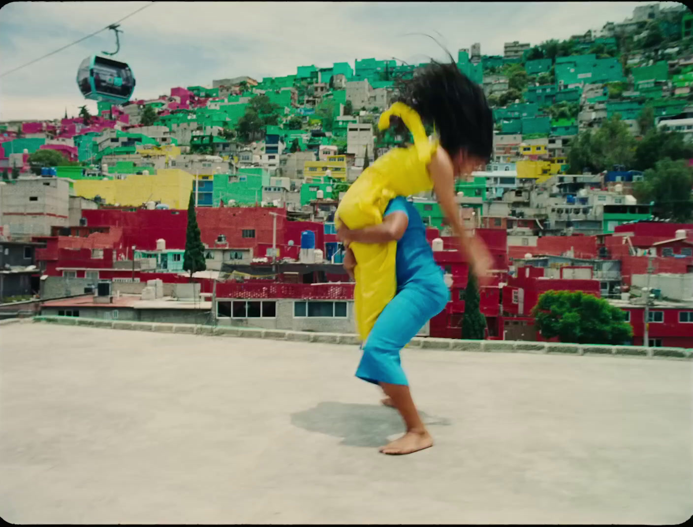 a person in a yellow shirt and blue pants doing a trick on a skateboard