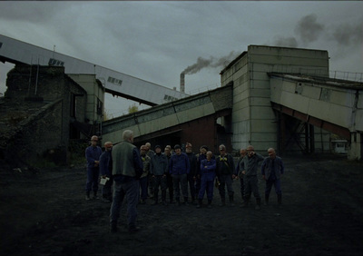 a group of people standing in front of a factory