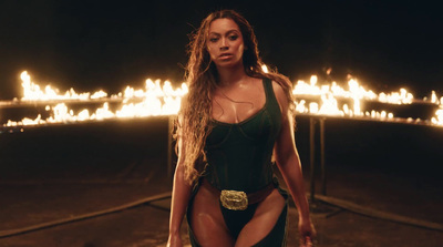 a woman in a bathing suit standing in front of fire