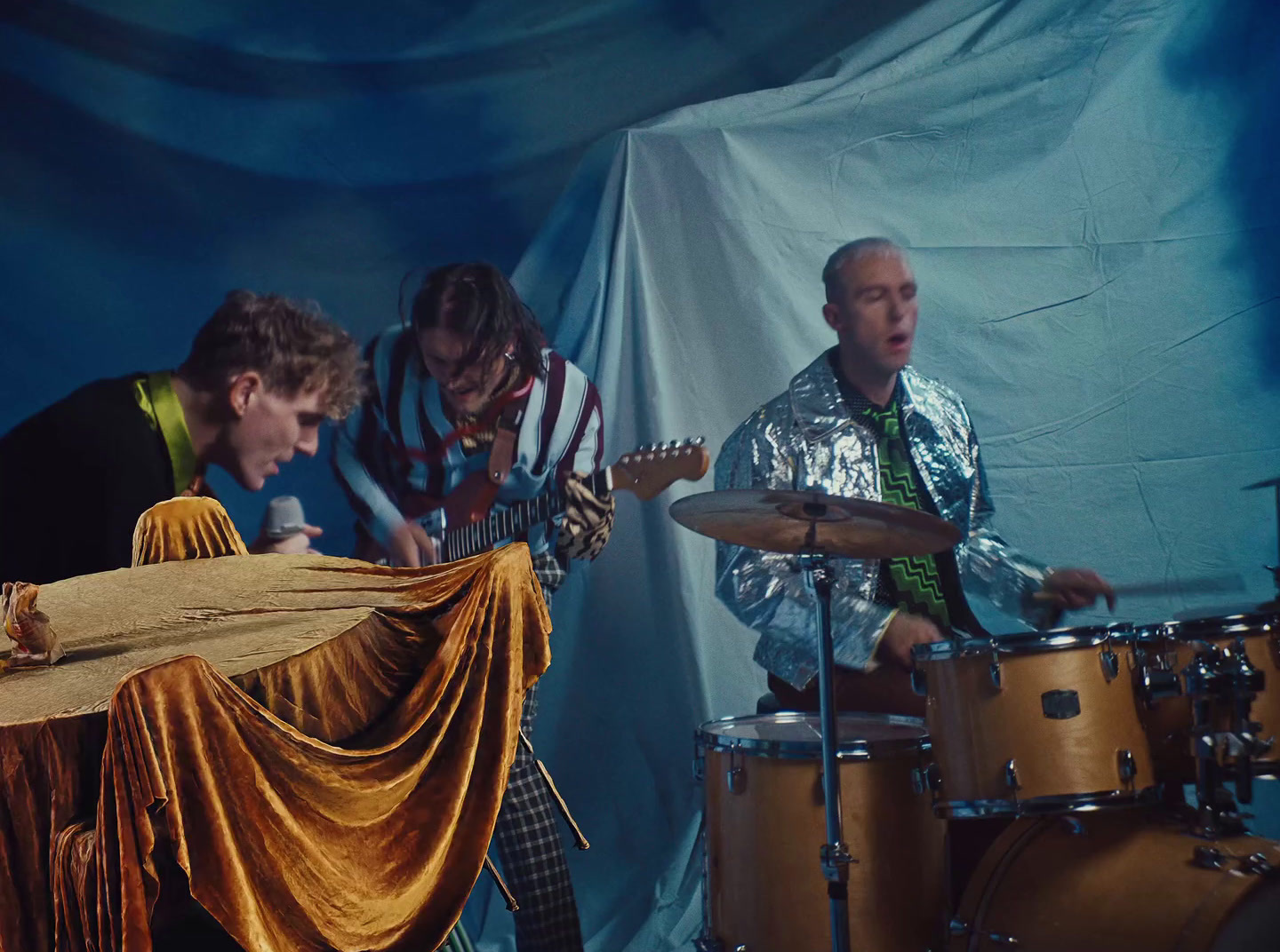 a group of men playing instruments in front of a blue background